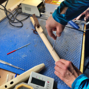 Creating the holes for the perfect cord on the wooden flute.